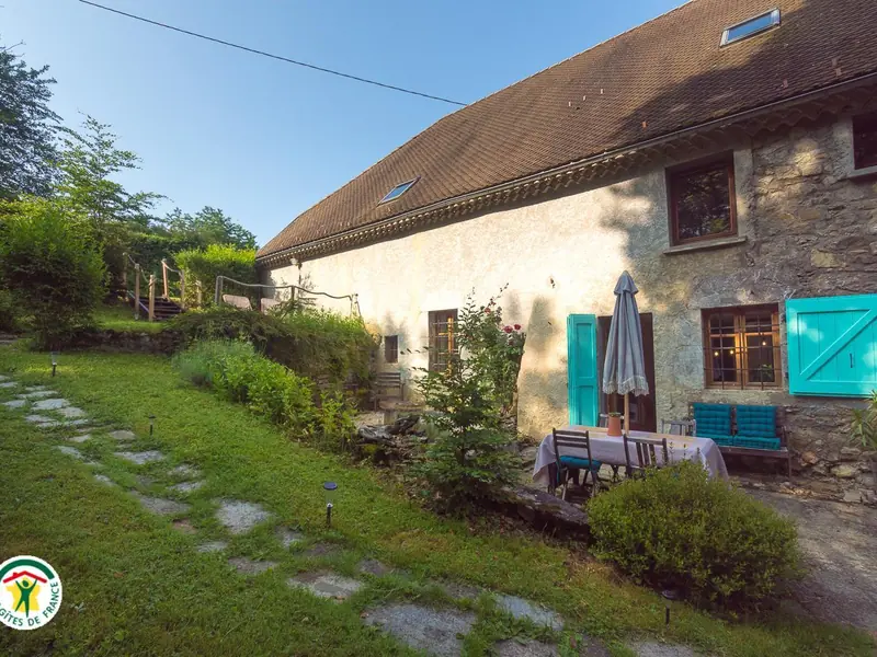 La longue façade du gîte et l'escalier menant au parking, en fin de journée