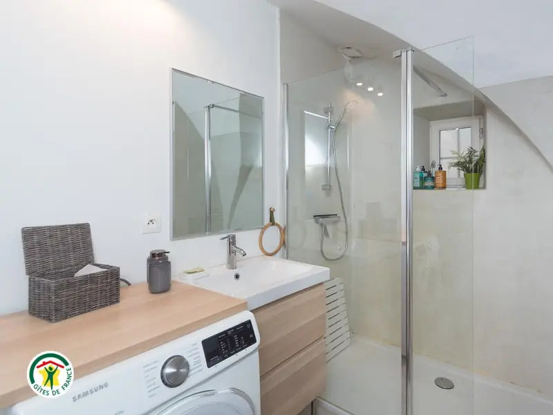 La salle d'eau du gîte, grande douche vitrée et vasque sur plan en bois